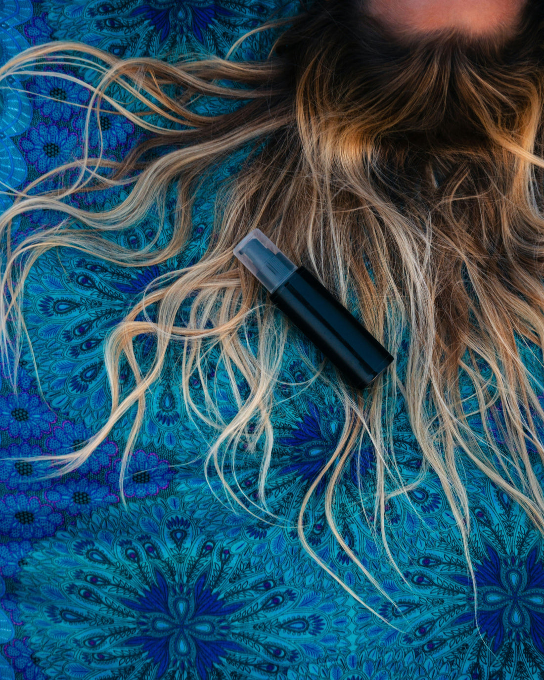 Woman's hair and container on a flat lay.