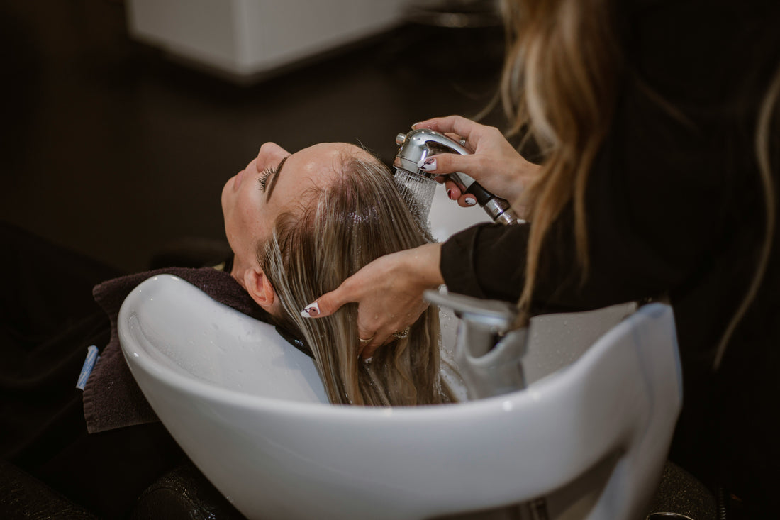 A woman undergoing hair cleaning in a saloon