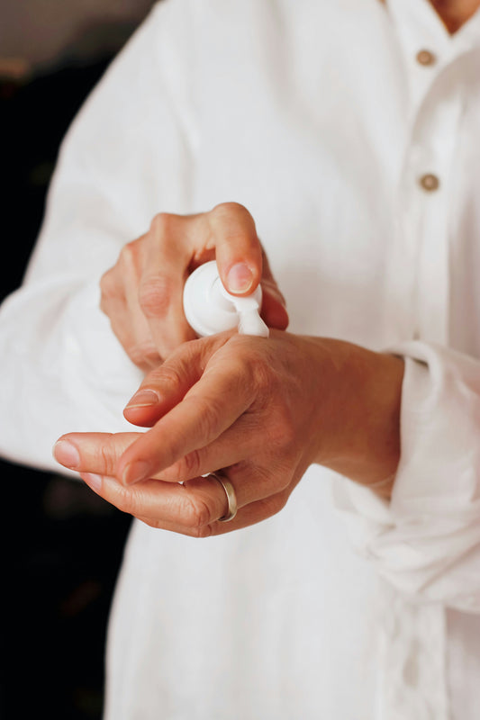 Woman using a botanical cream on hand.