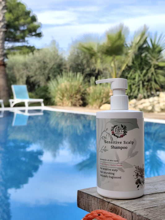 Shampoo bottle on a wooden ledge by a pool with greenery in the background